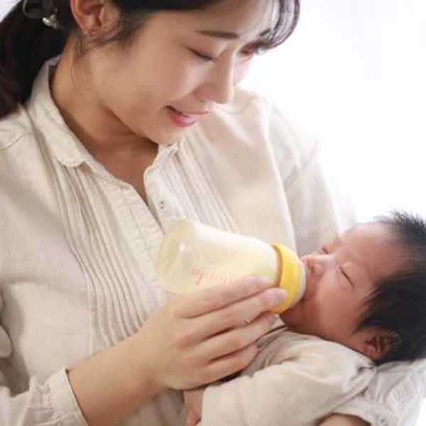 Mother holding baby feeding it a bottle