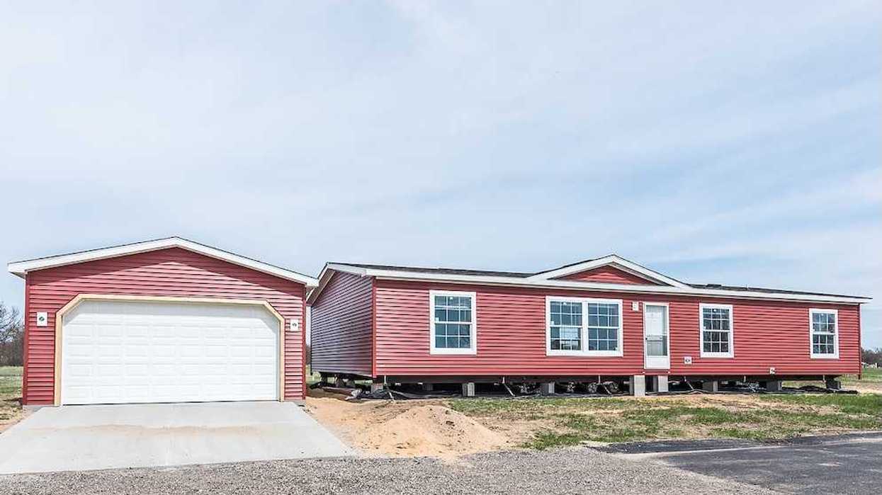 New manufactured home with red vinyl siding and windows