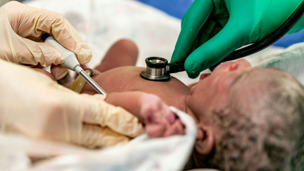 Newborn being checked with a stethoscope