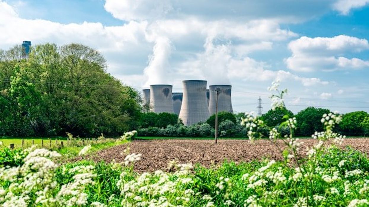 Nuclear reactor towers next to a farm field.