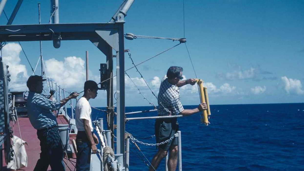 Oceanographic operations on the Coast and Geodetic Survey Ship PIONEER. Attaching Nansen water sampling bottle and thermometer to wire.