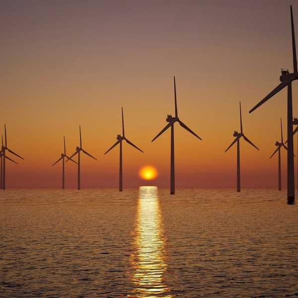 off shore wind farm against setting sun