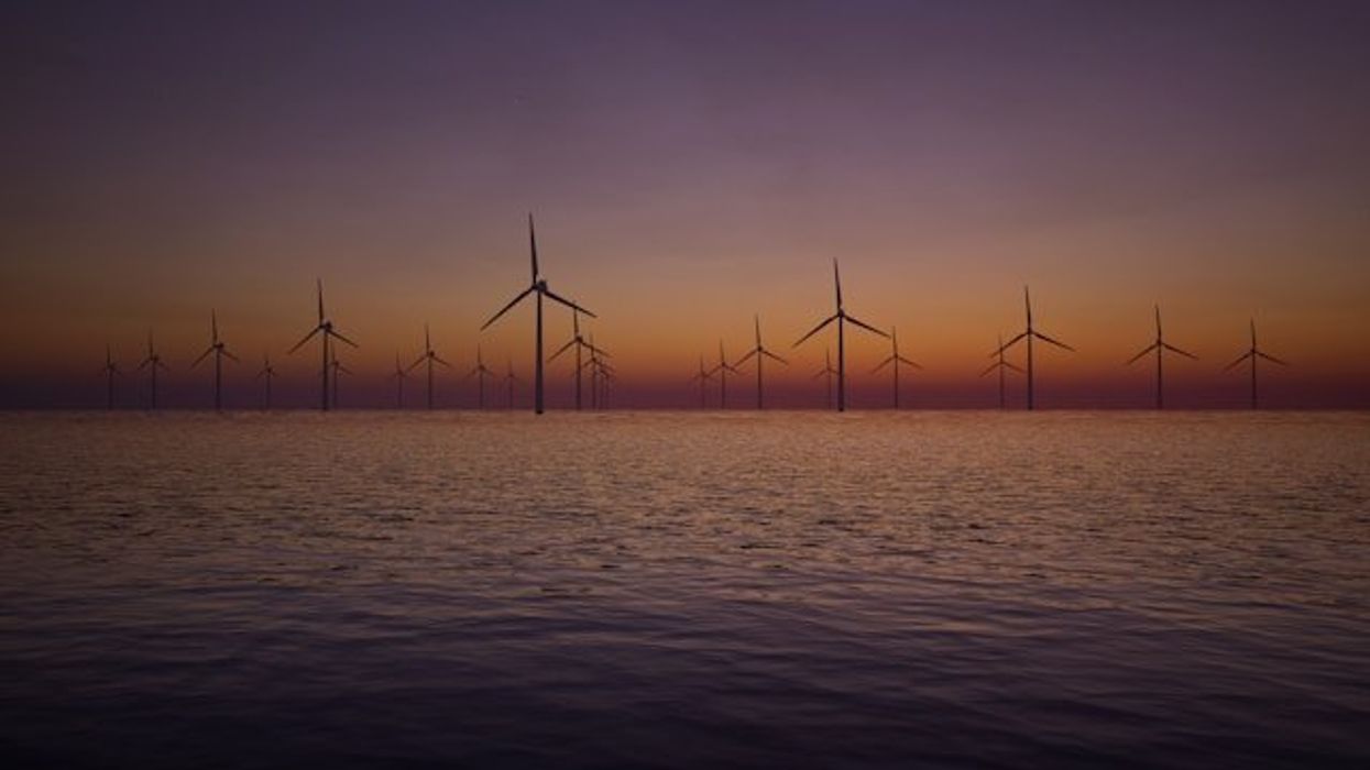 Offshore wind turbines with the sunset in the background.