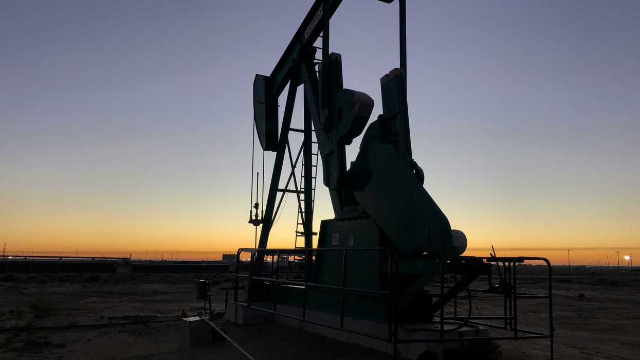 Oil pump jack silhouetted against a twilight sky.
