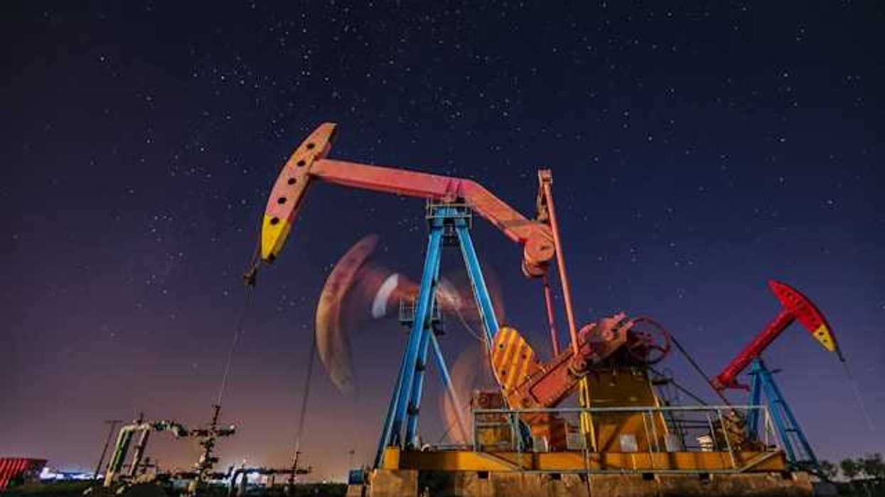 Oil pump jacks at night with a starry sky in the background