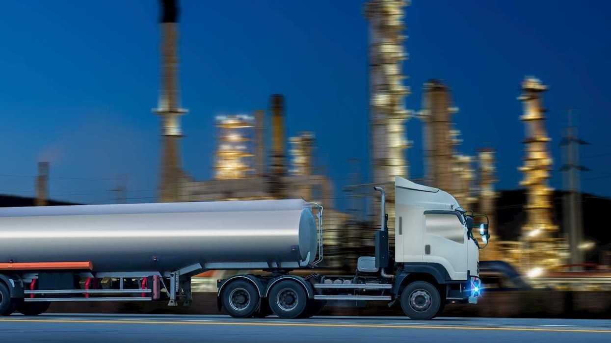 Oil tanker truck in front of a refinery