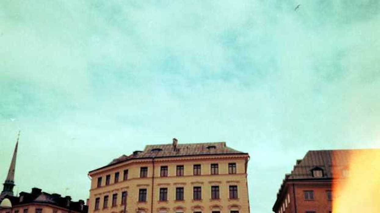 Old buildings stand against a bright blue sky