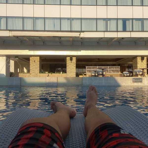 Pair of feet belonging to a person lounging poolside
