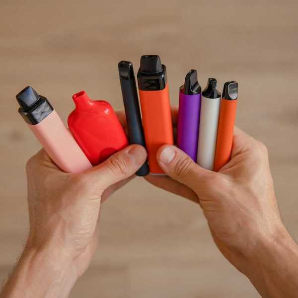 Pair of hands holding assorted vaping devices