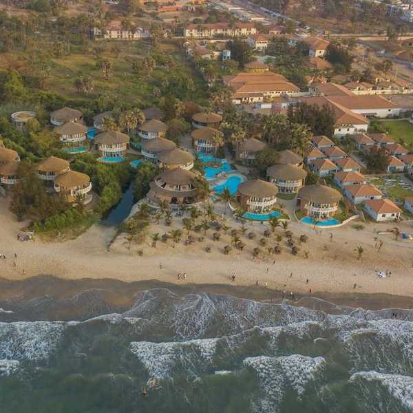 Panoramic drone view of Balafon Beach Resort on Kololi Beach in Gambia shows close proximity of ocean and inland residences