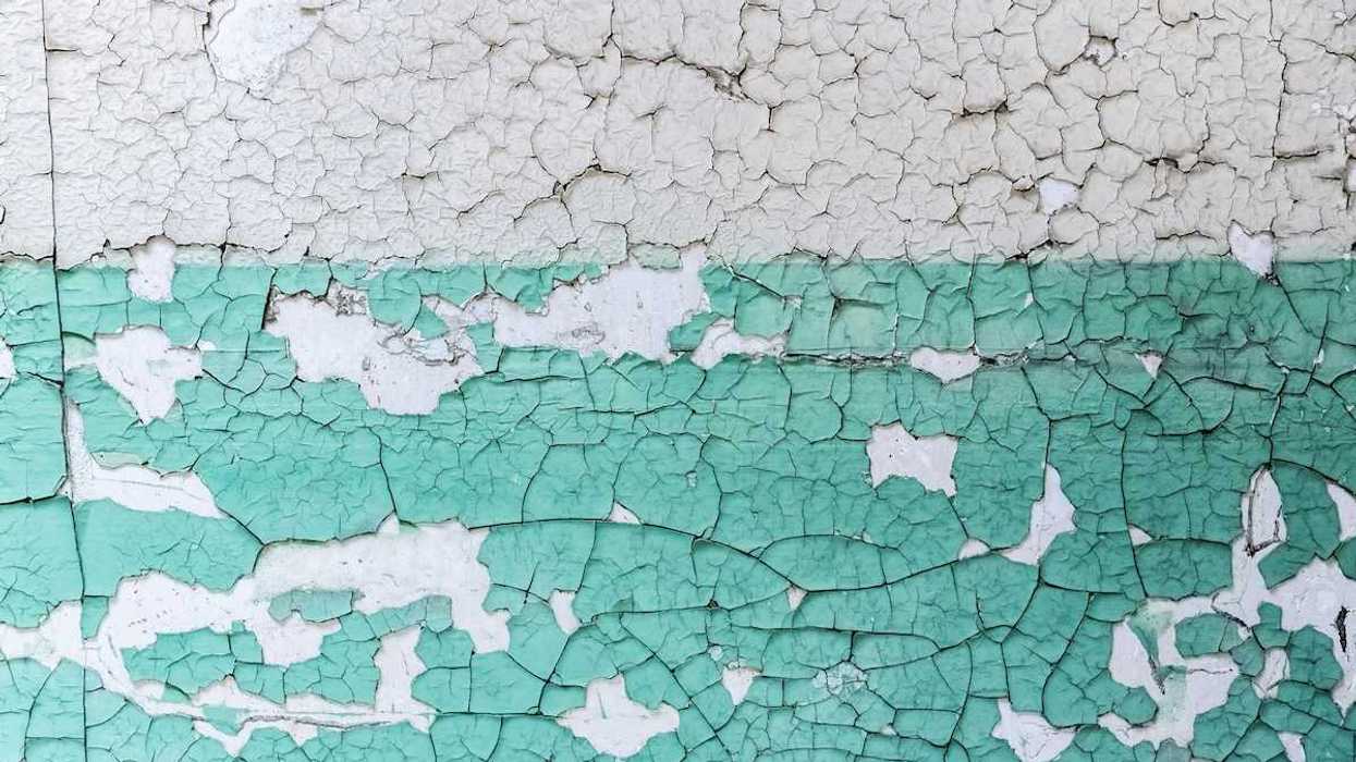 Peeling white and teal-colored paint
