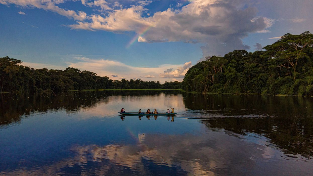 people crossing river in canoe