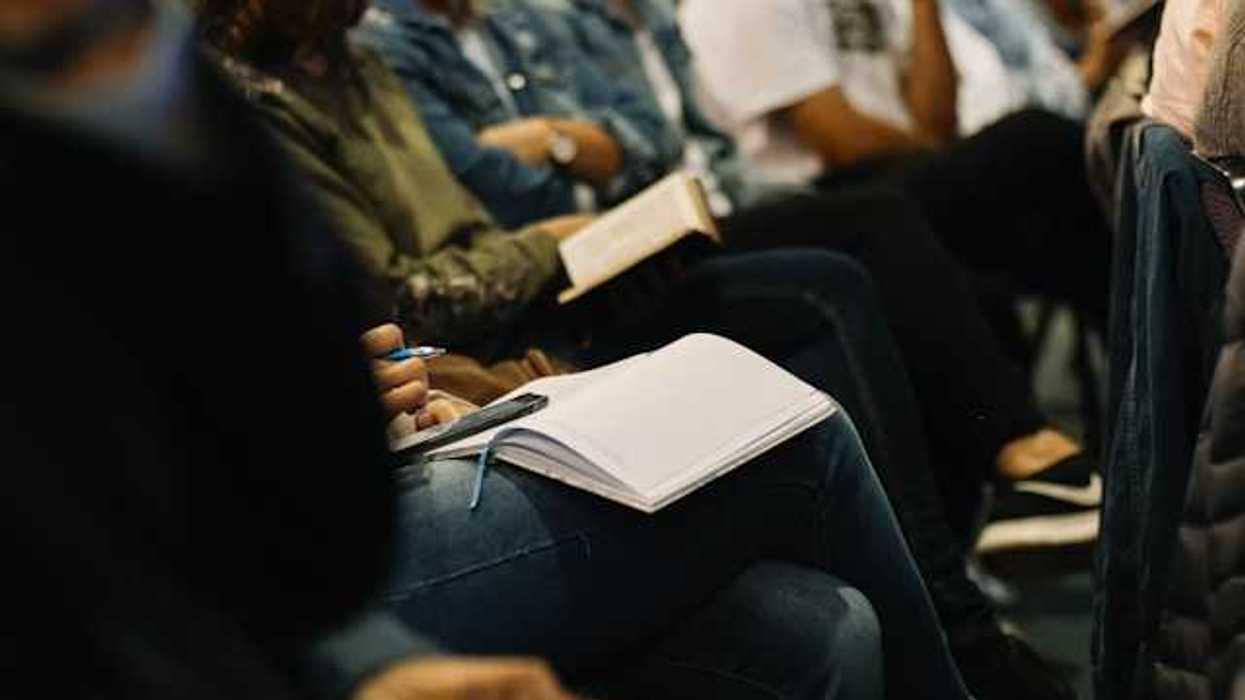 People gathering in chairs with notebooks