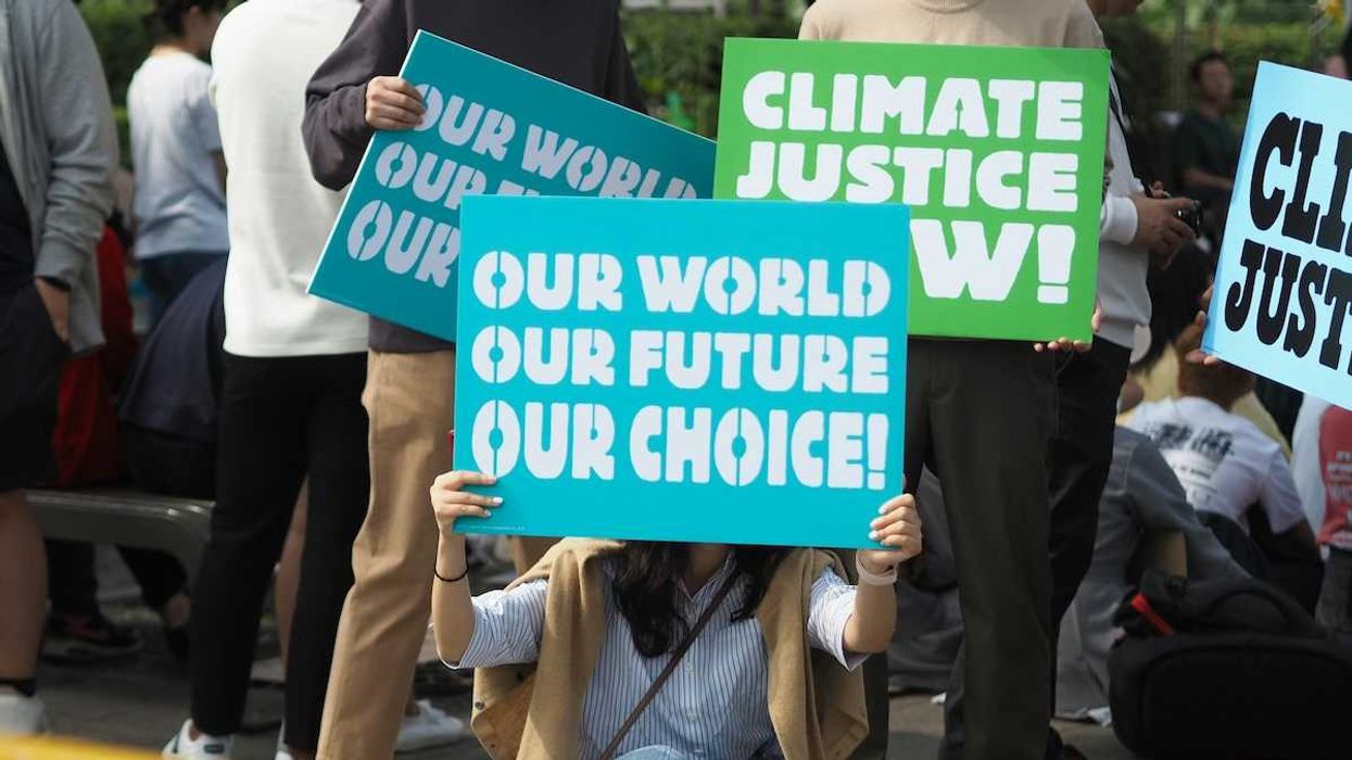 People holding Climate Justice signs "Our World Our Future Our Choice'