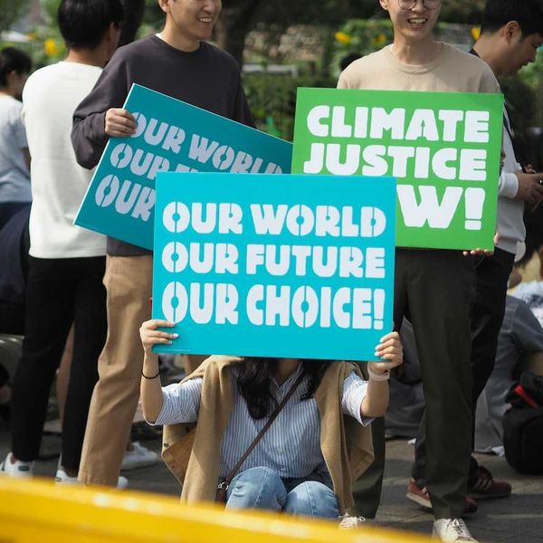 People holding Climate Justice signs "Our World Our Future Our Choice'