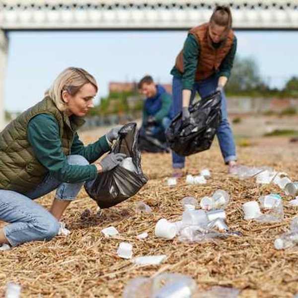People on a beach cleaning up plastic waste
