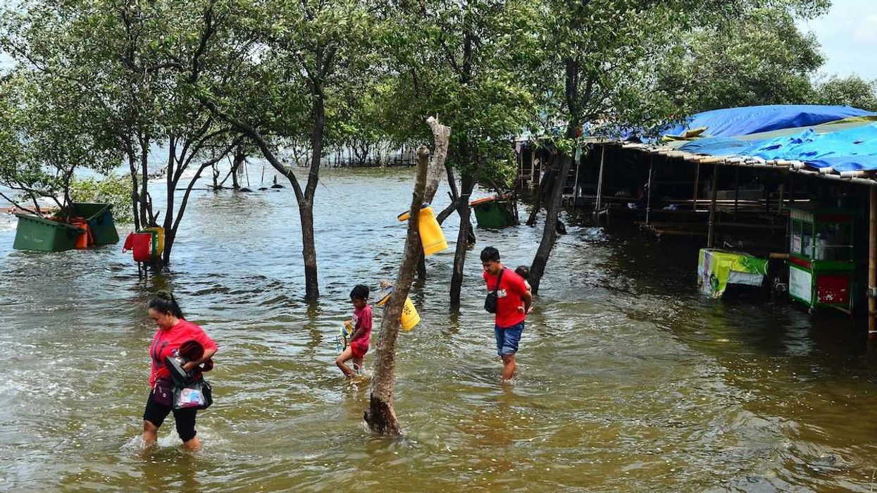 people wading through floodwaters