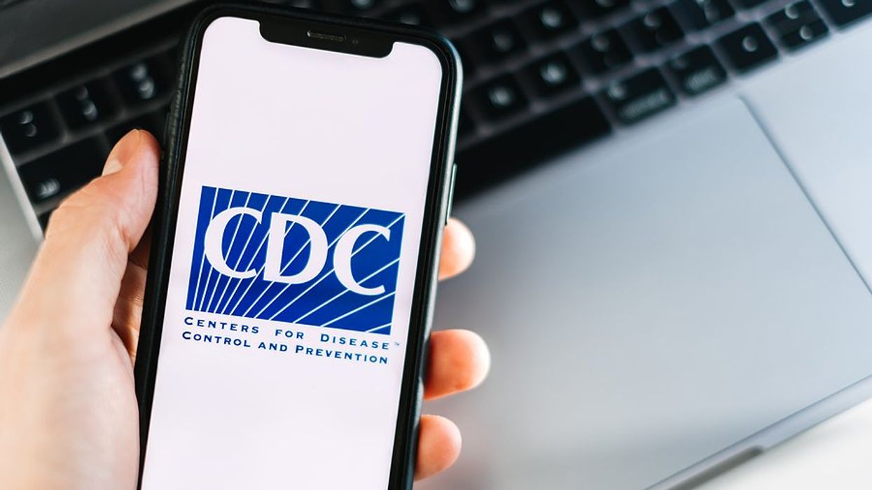 Person looking at mobile phone with the CDC logo on the screen.