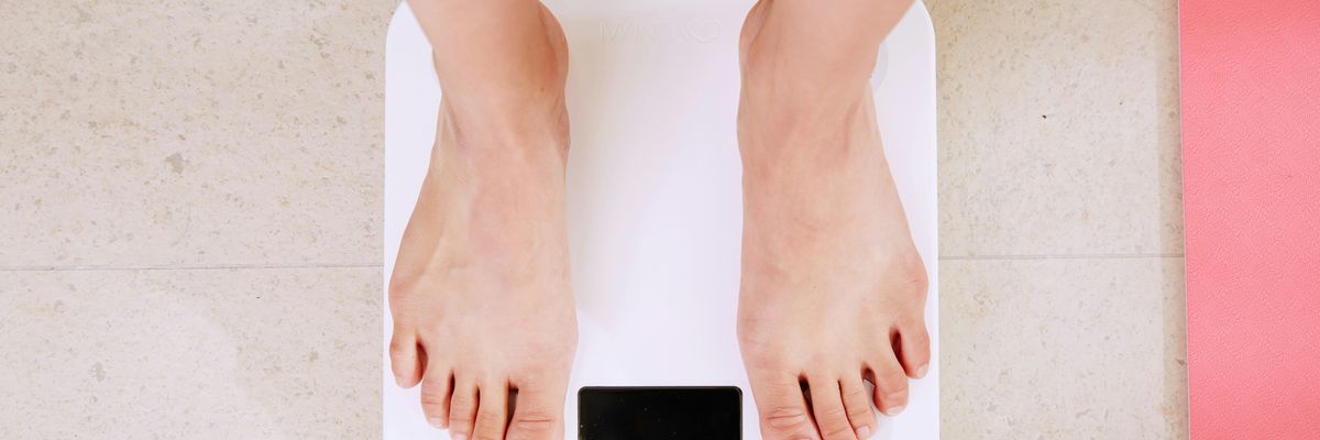 person standing on white digital bathroom scale