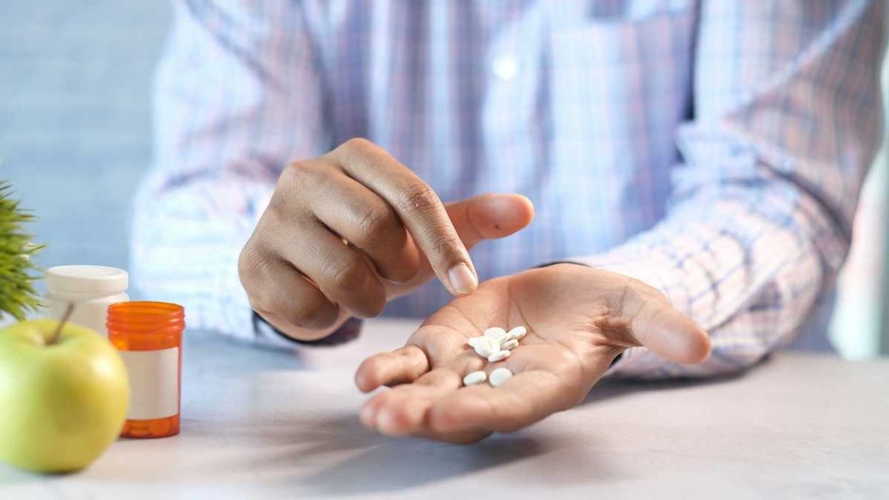 person with about a dozen pills in the palm of their hand