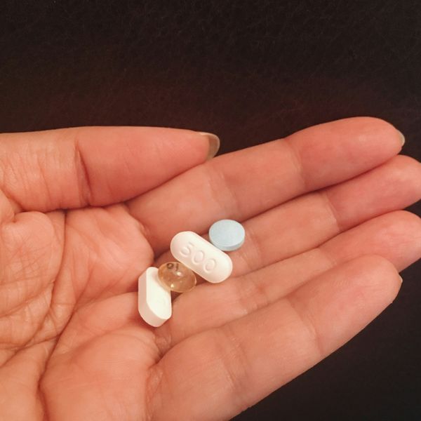 person woman holds a handful of supplements