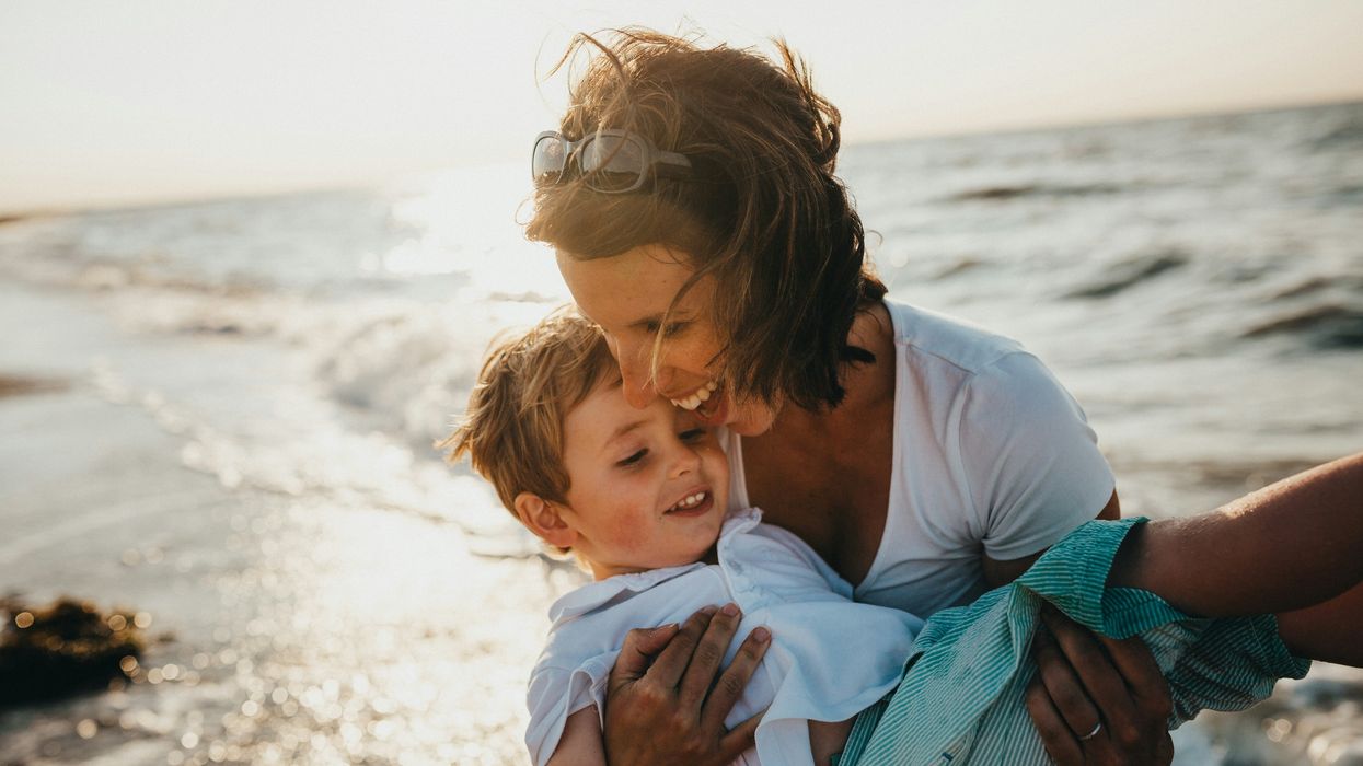 photo of mother and child beside body of water.
