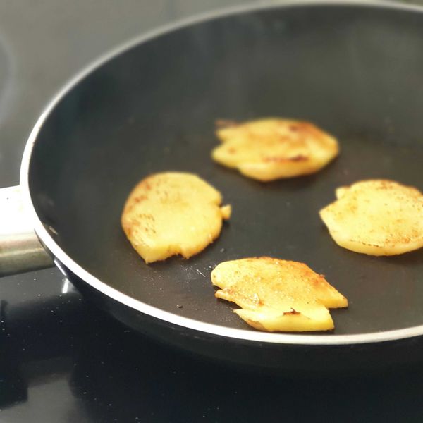 Pieces of ginger fying in a nonstick pan