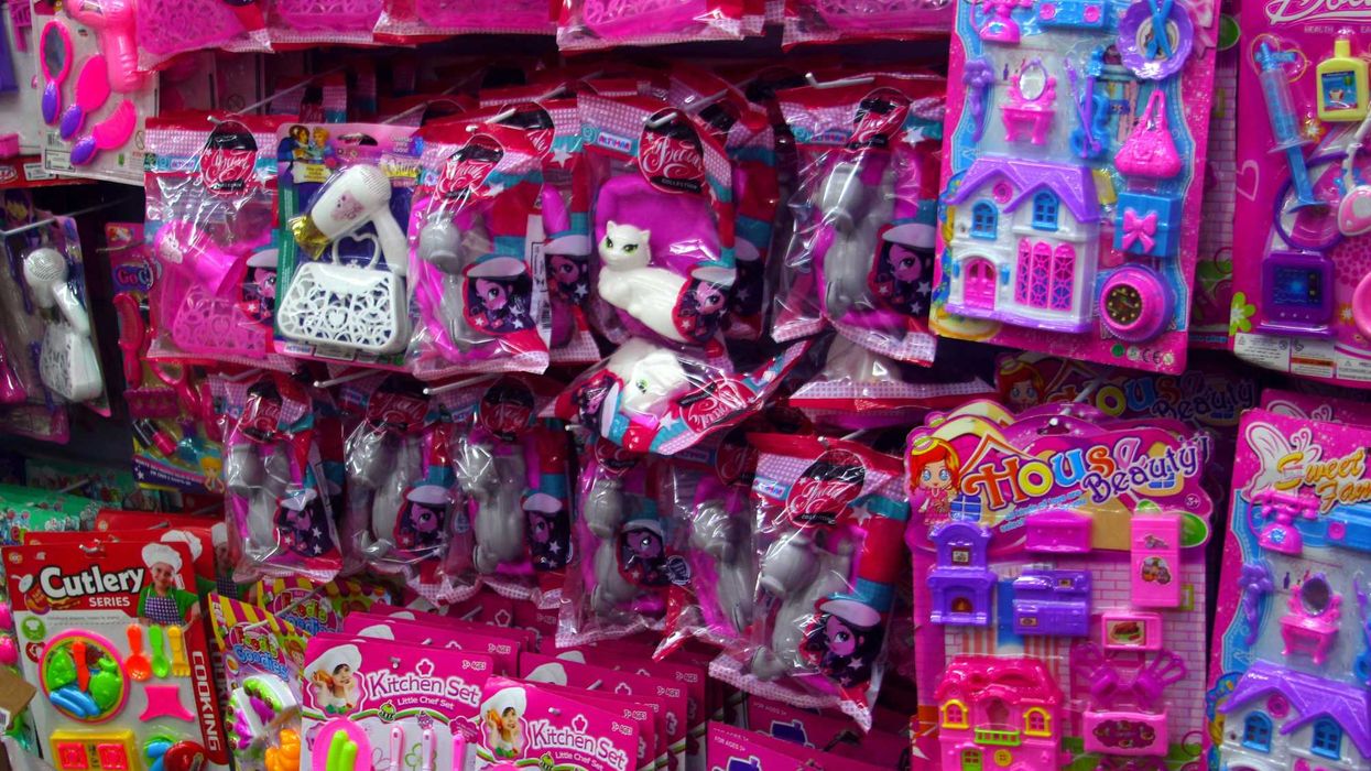 Pink plastic toys and accessories are displayed on racks for sale.