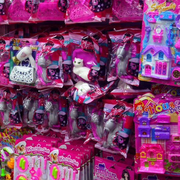 Pink plastic toys and accessories are displayed on racks for sale.