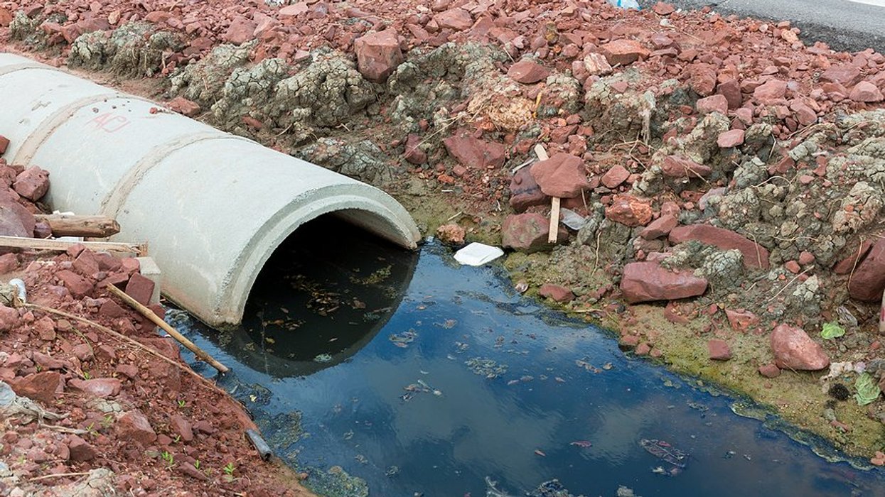 Pipe with dirty water coming out of it.