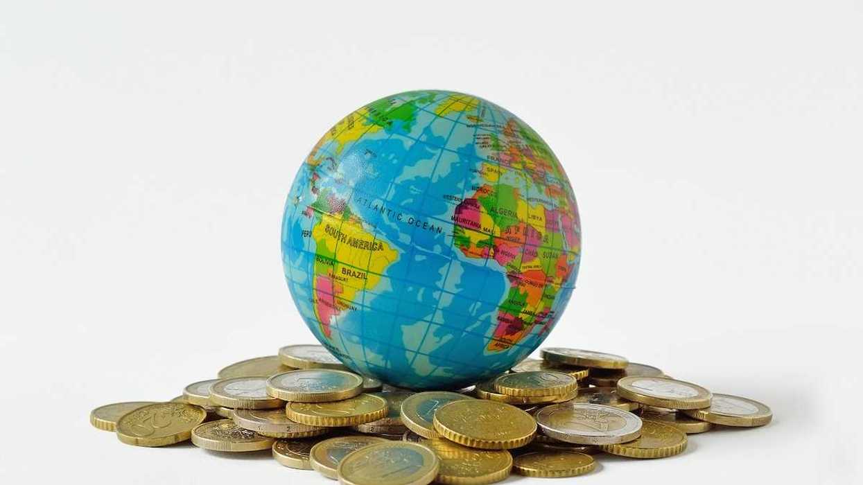 Planet earth on pile of coins - Concept of relationship between money, economic growth and planet earth