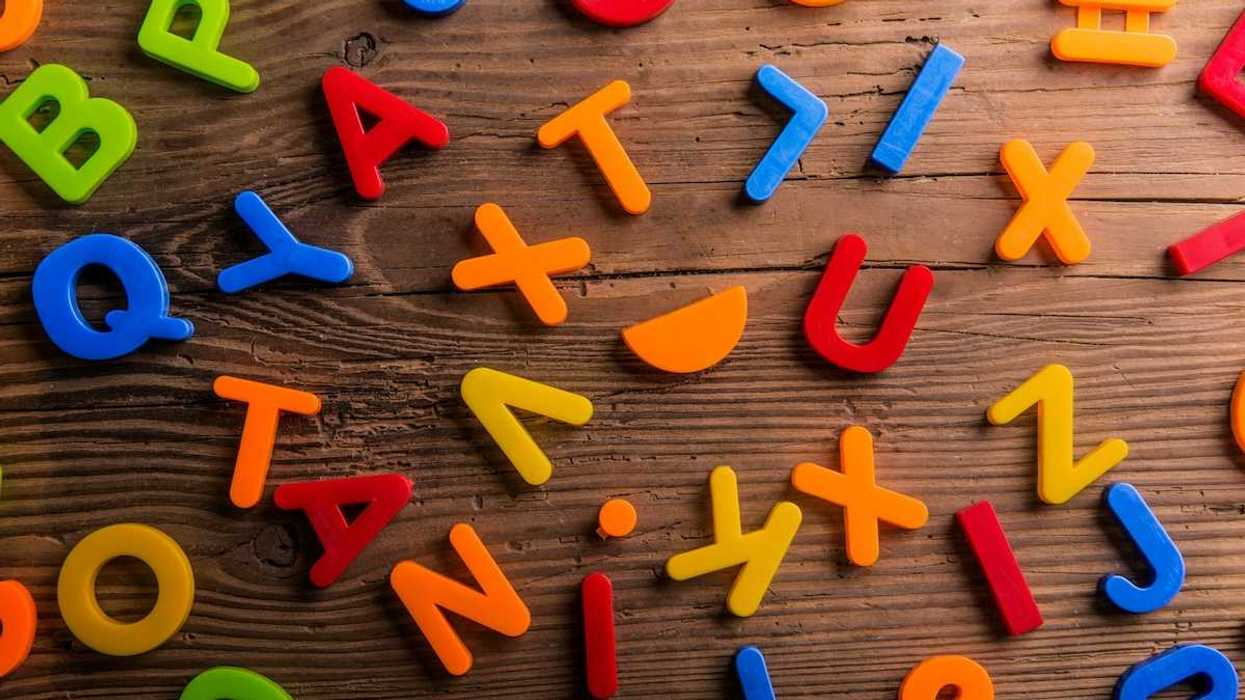 plastic letters randomly scattered onto a wooden background