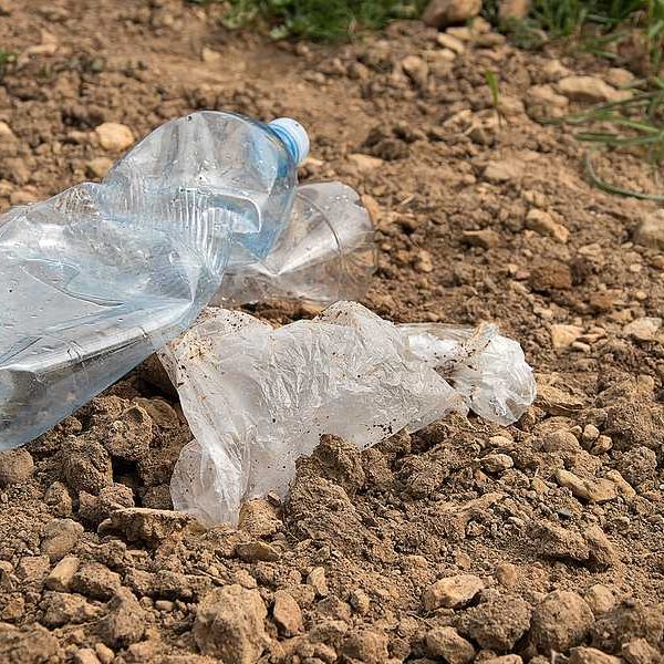 Plastic trash sitting on dirt