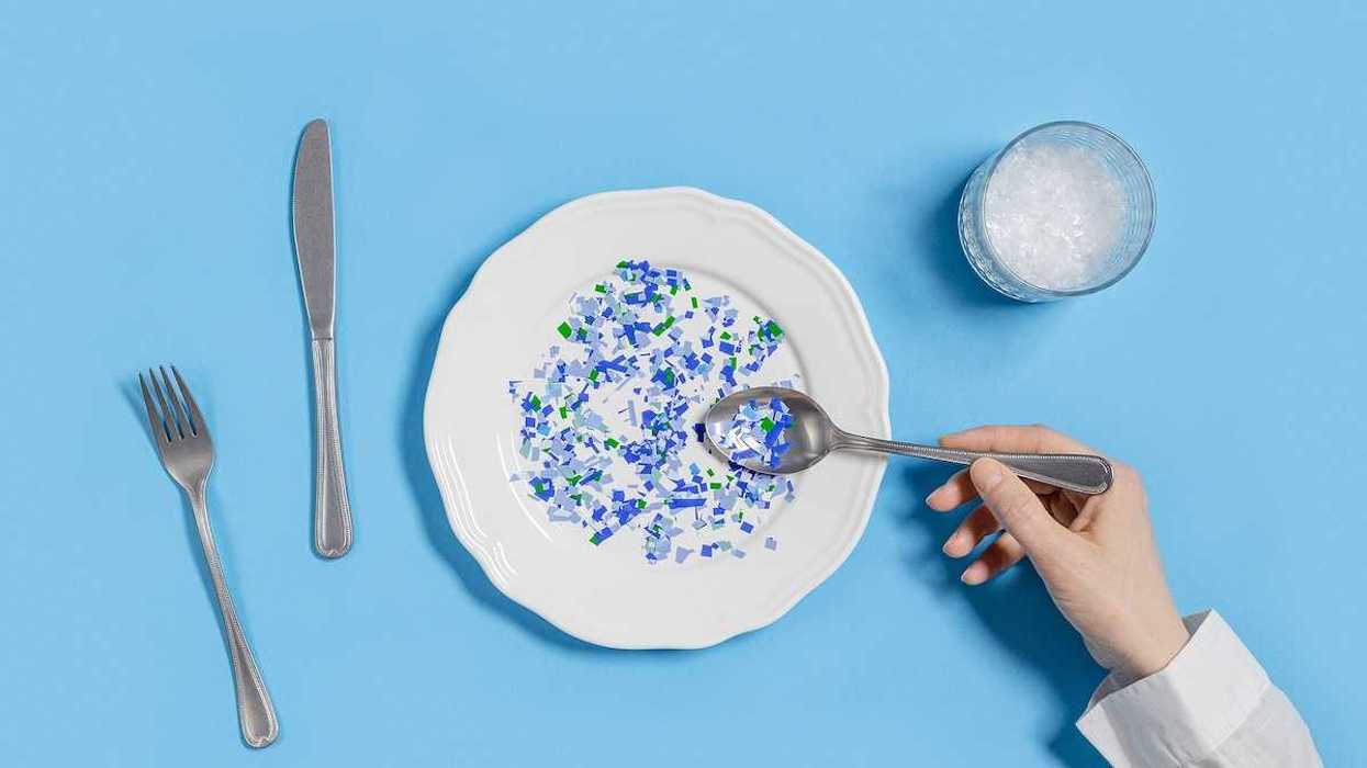 Plate with plastic pieces instead of food and glass of microplastics instead of water.
