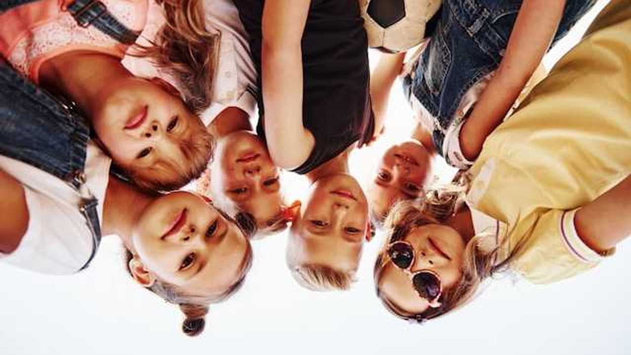 Portrait of a group of kids huddled together with a soccer ball
