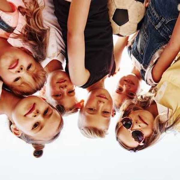 Portrait of a group of kids huddled together with a soccer ball