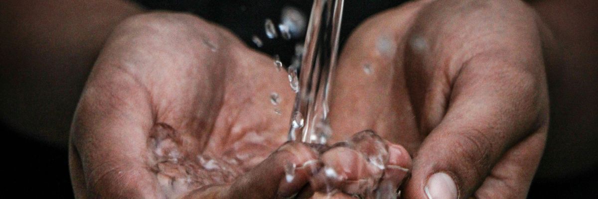 pouring water on person's hands
