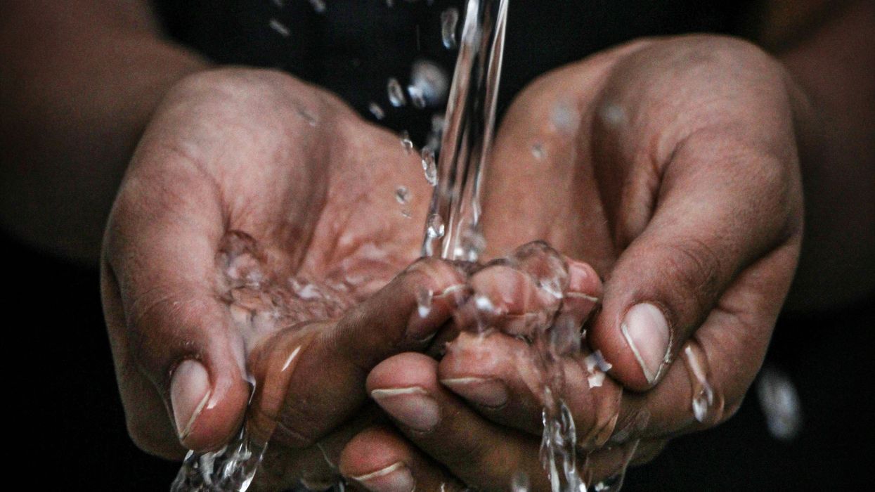 pouring water on person's hands