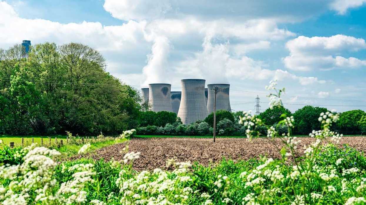 Power plant adjacent to plowed field and wildflowers
