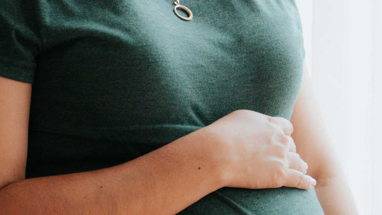 Pregnant woman's hands over belly.