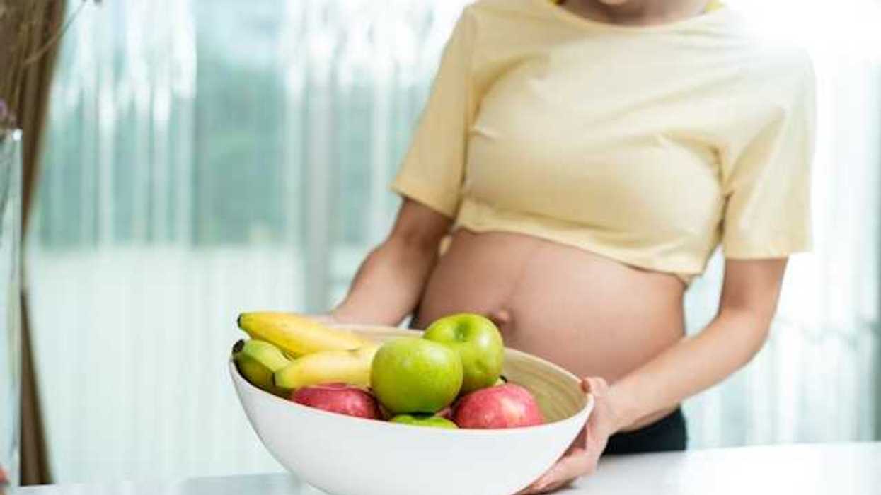 Pregnant woman with a bowl of fruit
