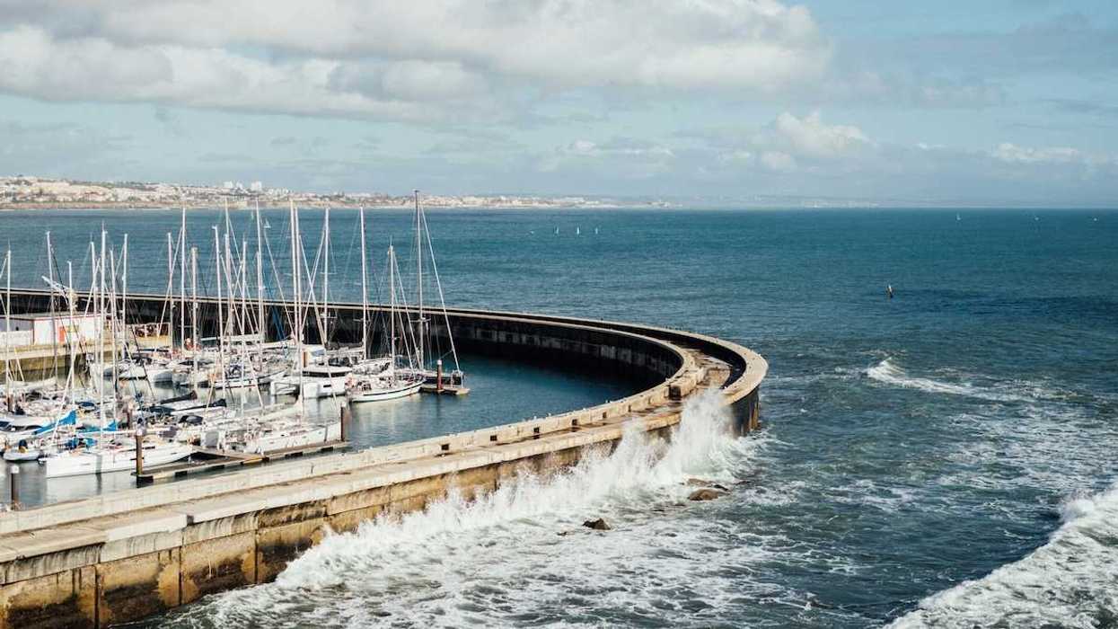 Protective sea wall sheltering multiple boats at harbor