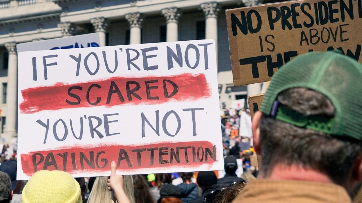 protester holding signs outside government building