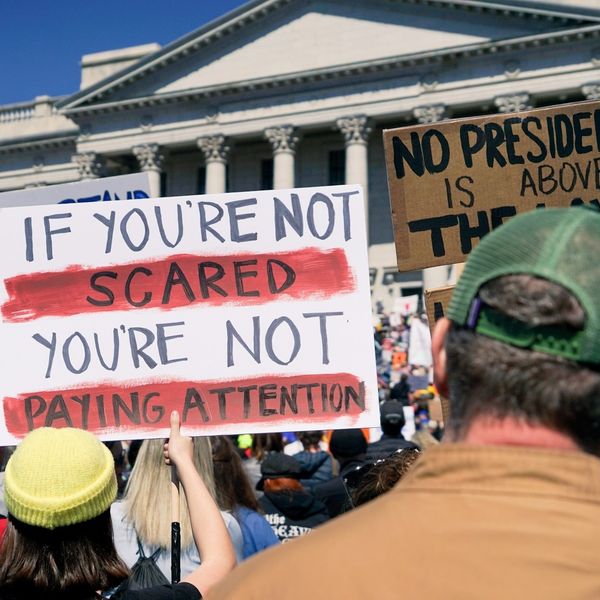 protester holding signs outside government building