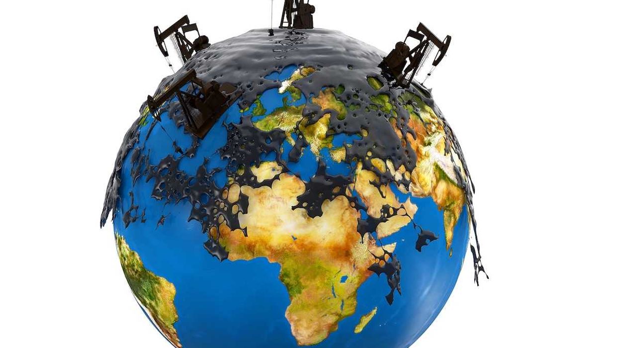 Pump jacks and oil spill over planet earth isolated on white background.