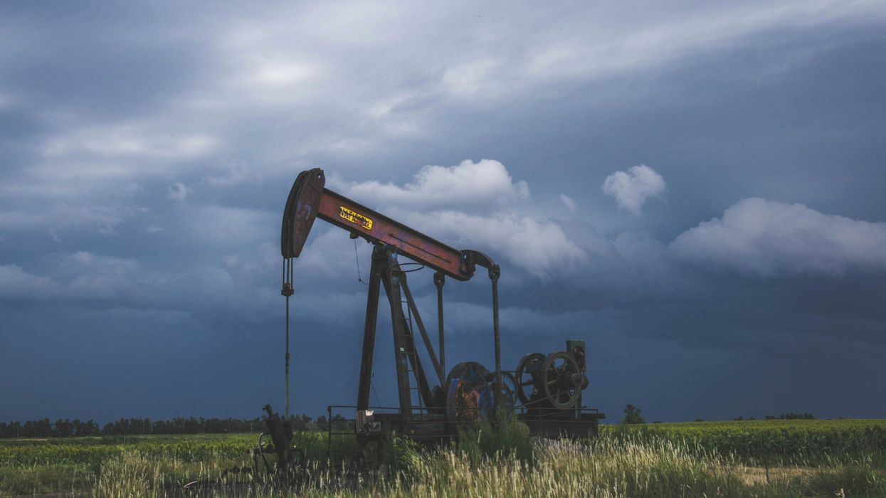 red and black heavy equipment on green grass field under white clouds during daytime