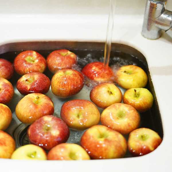 Red apples being washed in a sink