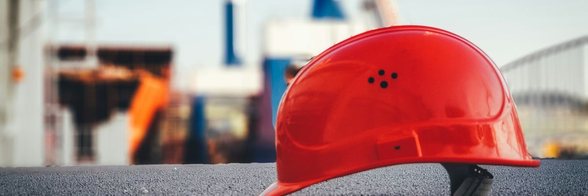 red hard hat on pavement\