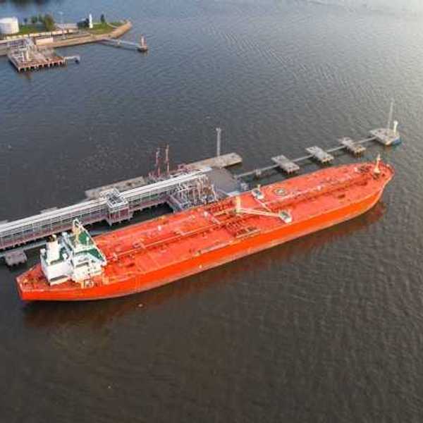 Red oil tanker at a dock