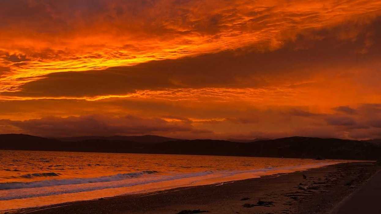Red sky reflected in a pink-tinged ocean